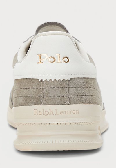 Szürke velúr sneaker fehér bőrből készült saroktabbal. Az hátul arany "Polo" és "Ralph Lauren" logók vannak blindítóan.