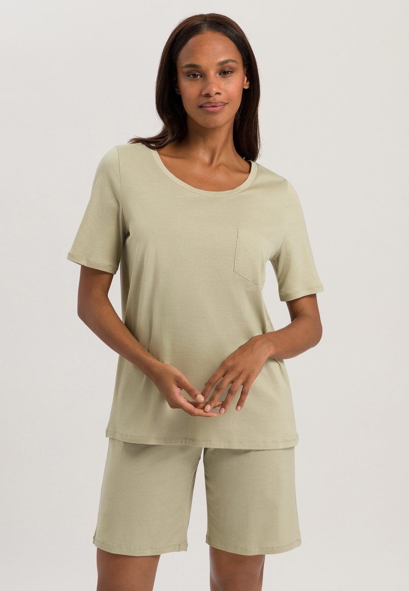 Conjunto de ropa de lounge de algodón verde oliva claro que incluye una camiseta de manga corta con cuello redondo y un bolsillo en el pecho, combinada con pantalones cortos hasta la rodilla.