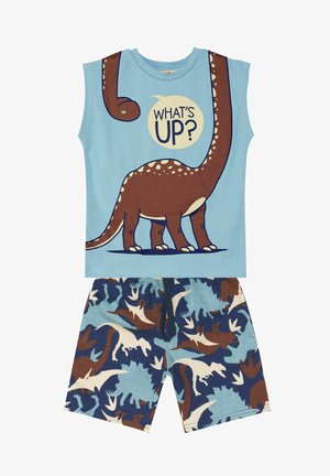 Das blaue ärmellose Top hat ein braunes Dinosaurier-Motiv und den Schriftzug "WAS GIBT'S?" Die Shorts haben ein mehrfarbiges Dino- und Blattmuster auf einem blauen Hintergrund.
