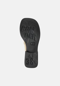 Black rubber shoe sole with embossed "CAM PER" logo and size "38," featuring a textured pattern and an overall rounded shape.