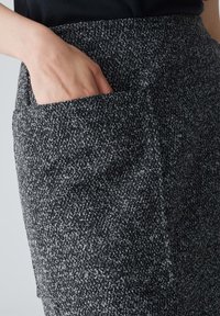Textuurlijke zwart-witte gestreepte rok met een zijzak, gemaakt van geweven stof, met een getailleerd ontwerp en rechte snit.