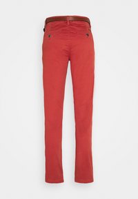 Pantalons rouges slim fit avec poches arrière à bouton et une ceinture marron, vus de dos sur un fond blanc.