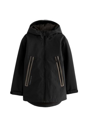 Musta hupullinen takki, jossa edessä vetoketju ja kaksi pystysuoraa vetoketjullista taskua beigeillä somisteilla, pitkät hihat ja hieman pidempi takasauma.