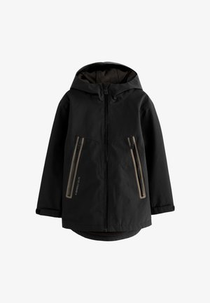 Črna jakna s kapuco z zadrgo spredaj in dvema navpičnima žepoma z zadrgo in bež obrobo, dolgimi rokavi ter malce daljšim zadnjim robom.