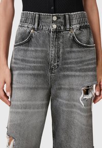 Hoge taille, grijze denim jeans met een verwerkte afwerking, voorzien van ruwe zomen, zichtbare stiksels en zilveren sluitingen.