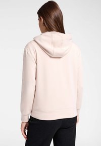 Sudadera rosa claro hecha de tela suave, con vista trasera que incluye una capucha con cordón, puños acanalados y un dobladillo ajustado.