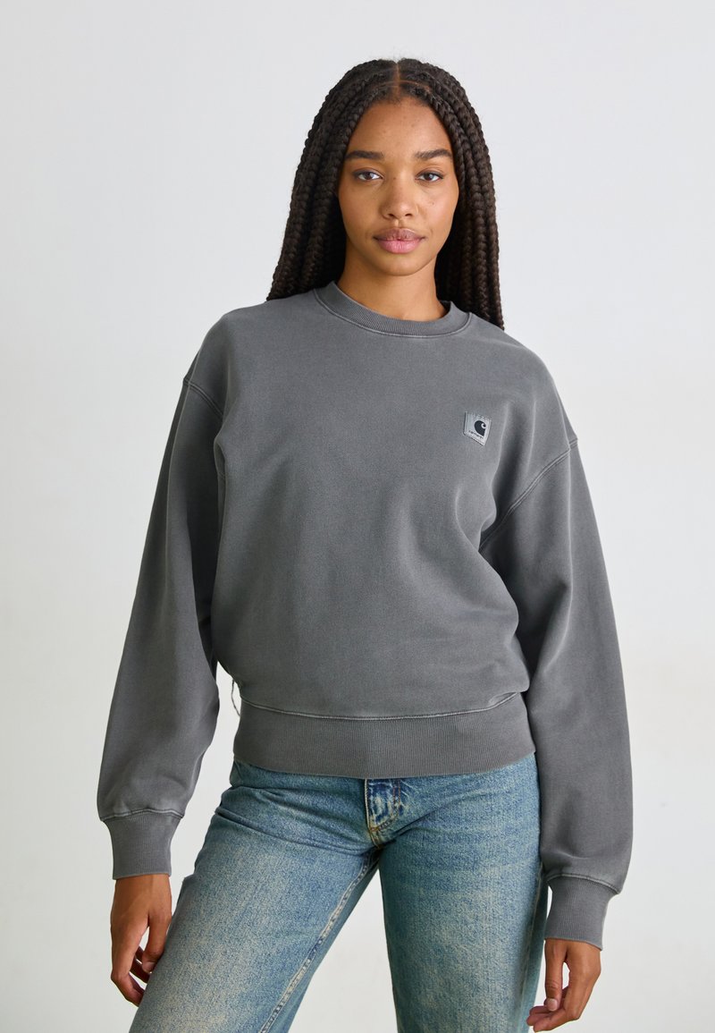 Grå fleece sweatshirt med rund hals, nedfallande axlar, ribbade ärmslut och nederkant. Har en liten logga patch på övre vänstra sidan. Avslappnad passform.