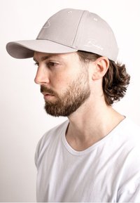 Gray baseball cap with a curved brim and a stitched logo on the front. The cap has a textured fabric finish.