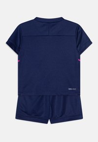 Tumedasee DRI-FIT spordikomplekt, mis koosneb lühikeste varrukatega toppist ja sobivatest lühikestest pükstest, roosa aktsendiga varrukatel. Võrgustruktuuri disain.