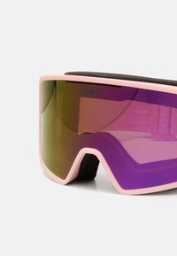 Occhiali da sci con montatura rosa, grandi lenti specchiate viola e imbottitura in schiuma nera. Presentano un logo sul lato sinistro superiore.