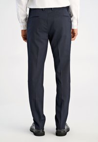 Marineblaue Anzughose mit maßgeschneiderter Passform, zwei Gesäßtaschen, glatter Textur und Bügelfalten, kombiniert mit schwarzen Schuhen.