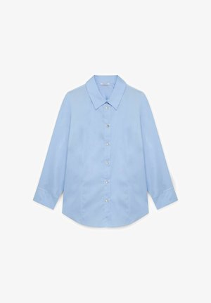 Chemise btn bleu clair avec col, manches longues et ourlet arrondi. Dotée de boutons imitant des perles et d'une texture de tissu lisse.