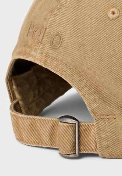 Khaki cotton cap with stitched "Polo" logo, curved brim, adjustable metal clasp, and textured fabric detail.