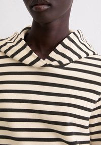 Gestreepte hoodie van zachte stof, met een crèmekleurige basis en smalle zwarte strepen, een trekkoord in de hals en een ontspannen pasvorm.