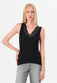 Black tank top featuring a V-neck with lace trim, sleeveless design, and a smooth, form-fitting texture paired with gray jeans.