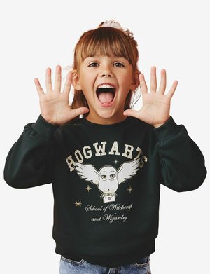Schwarzer Sweatshirt mit einem großen Grafik einer Eule mit Flügeln und dem Text "HOGWARTS Schule für Hexerei und Zauberei" in Creme.