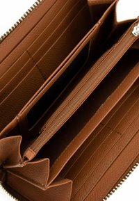 Braune Lederbrieftasche, geöffnet, um Kartenschlitze, zentrale, mit Reißverschluss versehene Münzfach und unterteilte Abschnitte im Inneren zu zeigen.