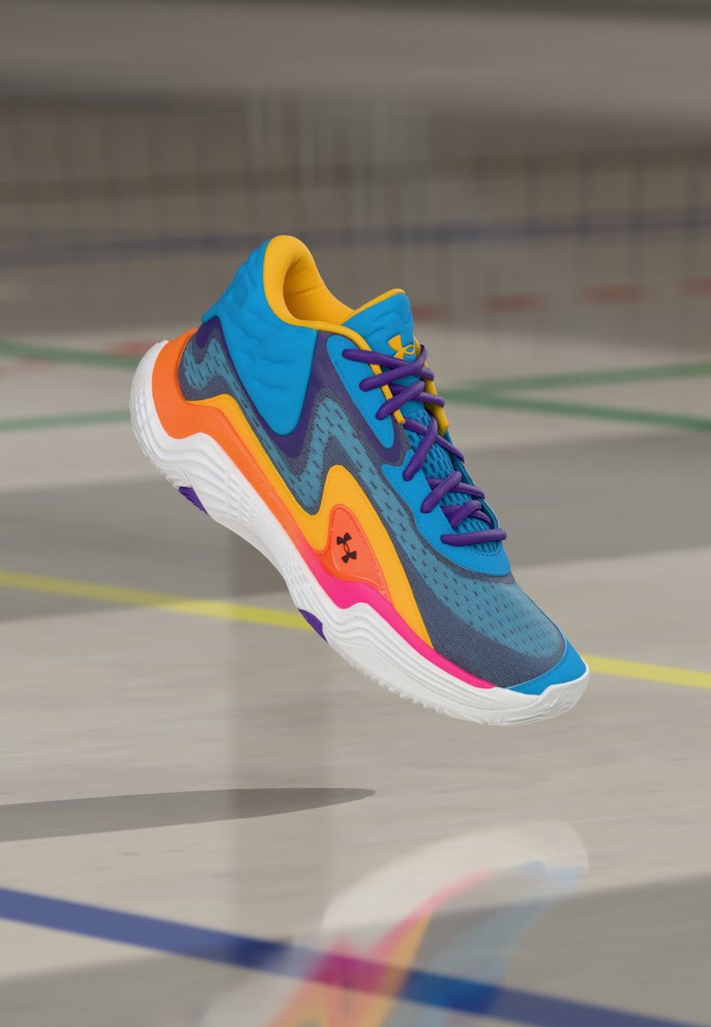 Αθλητικό πολύχρωμο αθλητικό παπούτσι με μπλε, κίτρινες, πορτοκαλί και ροζ λεπτομέρειες, μωβ κορδόνια, στον αέρα πάνω από το δάπεδο γυμναστηρίου με γραμμές γηπέδου.
