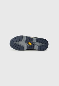 Dark blue and gray shoe sole with deep treads and a yellow Vibram logo at the center, isolated on a light background.