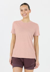 Ljusrosa t-shirt med kort ärm i mjukt tyg, med rundad halsringning och en lätt melerad struktur, kombinerad med mörka kortbyxor.