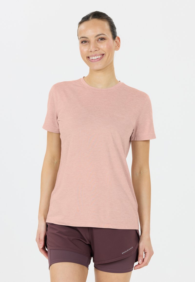 Ljusrosa t-shirt med kort ärm i mjukt tyg, med rundad halsringning och en lätt melerad struktur, kombinerad med mörka kortbyxor.