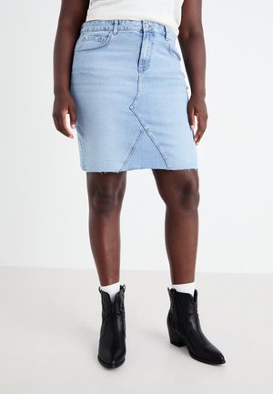 Light blue denim skirt with a diagonal seam, frayed hem, and a fitted silhouette, paired with black ankle boots and white socks.