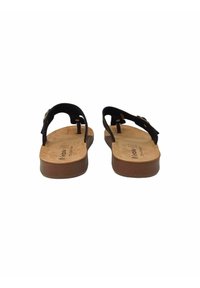 Sandali in pelle nera con soletta in sughero marrone e suola in gomma piatta, dotati di cinturino regolabile e dettaglio con fibbia in metallo.