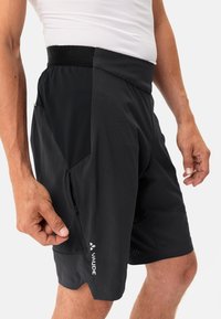 Pantalones cortos de ciclismo negros, fabricados con un tejido ligero, que cuentan con un diseño transpirable, una cinturilla elástica y un bolsillo con cremallera en el lateral.