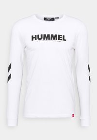 Witte lange mouwen shirt met zwarte "HUMMEL" tekst en logo. Bevat zwarte chevronstrepen op de mouwen. Gemaakt van lichtgewicht katoenmateriaal.