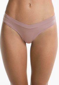 Dunne, naadloze roze bikini-slip met een hoge, overlappende taillebandontwerp. Gemaakt van zachte, rekbare stof en heeft een minimalistische snit.