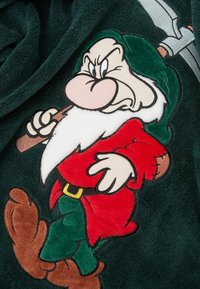 Zielony polarowy koc z haftowanym rysunkowym karłem w czerwonym, z białą brodą, brązowymi butami i trzymającym kilof.