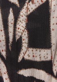 Musta kangas, jossa on teksturoitu, abstrakti kuosi kermansävyisellä ja ruosteenvärisellä. Esittelee epäsäännöllisiä muotoja ja pehmeitä reunoja, luoden kerroksellista ilmettä.