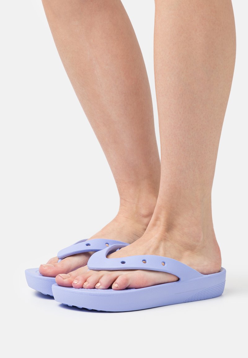 Infradito viola con una suola spessa e dettaglio della fascia a forma di V, dotate di fori di ventilazione e una suola testurizzata per una buona aderenza.