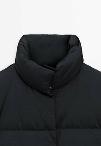 Black puffer jacket with a high, thick collar. Features a smooth, slightly shiny texture and a quilted pattern on the body.