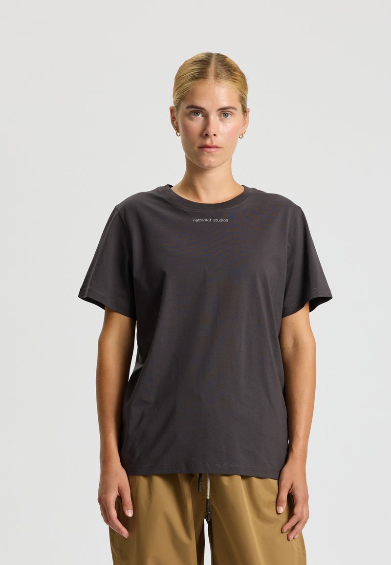 Donkergrijze katoenen T-shirt met een ronde halslijn en korte mouwen. Heeft subtiele branding in lichtgrijs op de borst. Gladde textuur.