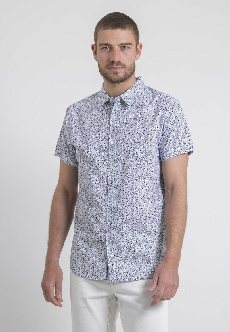 Chemise à manches courtes avec boutonnière en bleu clair, ornée d'un motif floral noir dispersé, faite en tissu léger avec un col et une coupe droite.