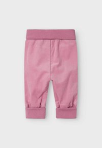 Rosa corduroybyxor med ribbade muddar, med en mjuk textur och en strömlinjeformad design. Elastisk midja för komfort och passform.
