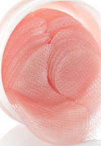 Patchs pour les yeux hydratants en gel dans un contenant rond. Les patchs sont de couleur pêche translucide avec une surface texturée et des bords incurvés et arrondis.