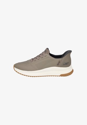 Zapatilla deportiva de color marrón claro con una parte superior texturizada y transpirable, diseño de cordones y una mediasuela de espuma blanca en contraste. Suela exterior de goma estriada.