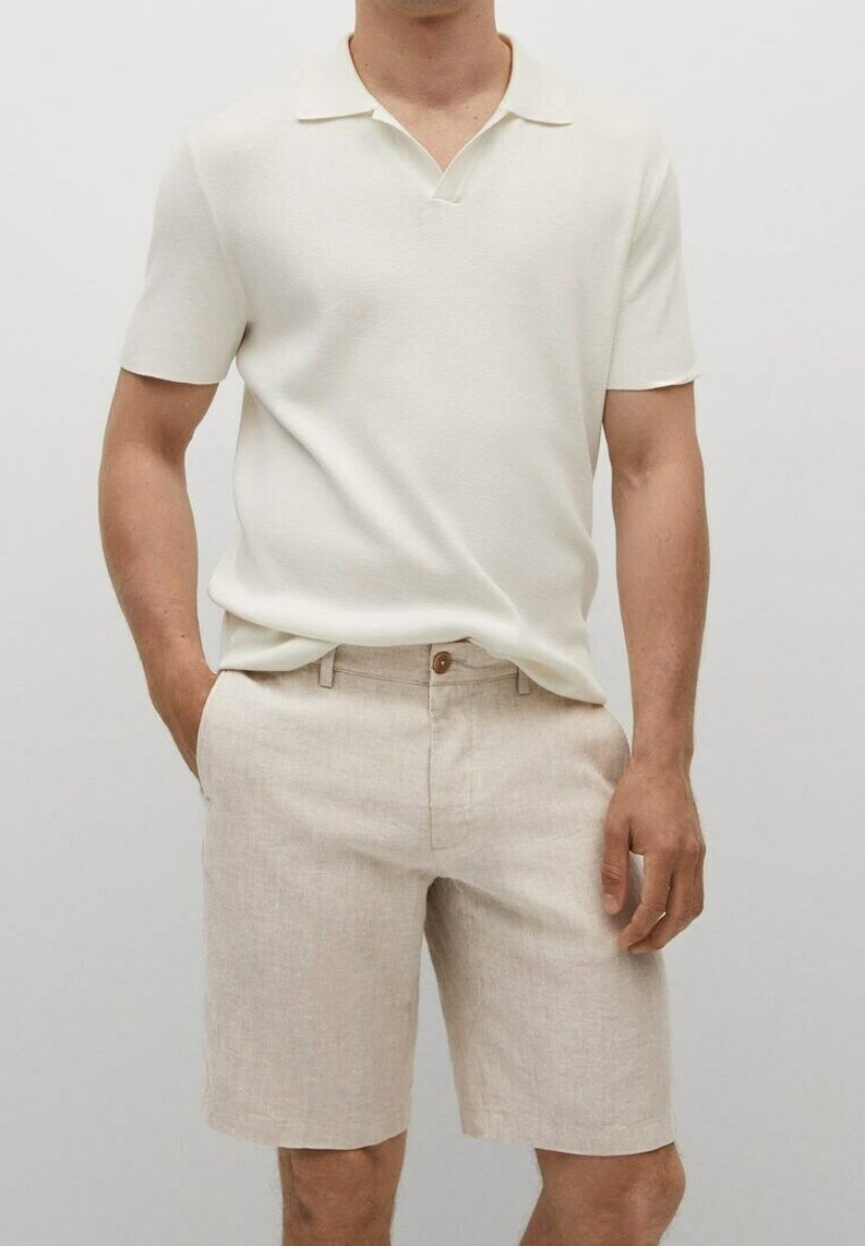Polo crème à manches courtes avec un col plat, associé à un short en lin beige doté d'une fermeture par bouton et de poches latérales.