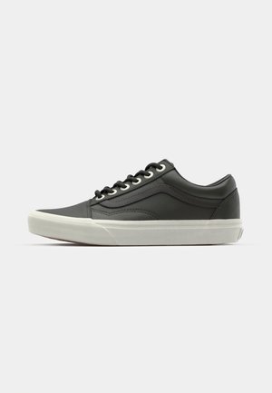 Sneaker in pelle nera con suola in gomma bianca, punta rotonda, dettagli laterali testurizzati e sei fori per i lacci. Design minimalista.