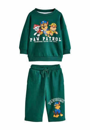 Roheline dressipluus ja lühikesed püksid komplekt, mis on kaunistatud Paw Patrol tegelastega. Dressipluusil on ümar kaelus ja trükitud graafika; lühikesed püksid on elastse vöökohtaga.