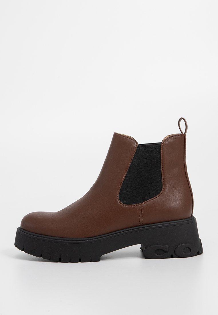 Braune Leder-Ankle-Boots mit einem schwarzen elastischen Seiteneinsatz und einer kräftigen schwarzen Sohle. Verfügt über eine Zuglasche auf der Rückseite für einfaches Anziehen.