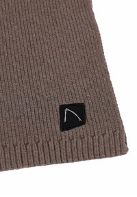Écharpe en tricot côtelé marron avec une finition texturée et une étiquette rectangulaire noire comportant un design graphique blanc dans le coin inférieur.