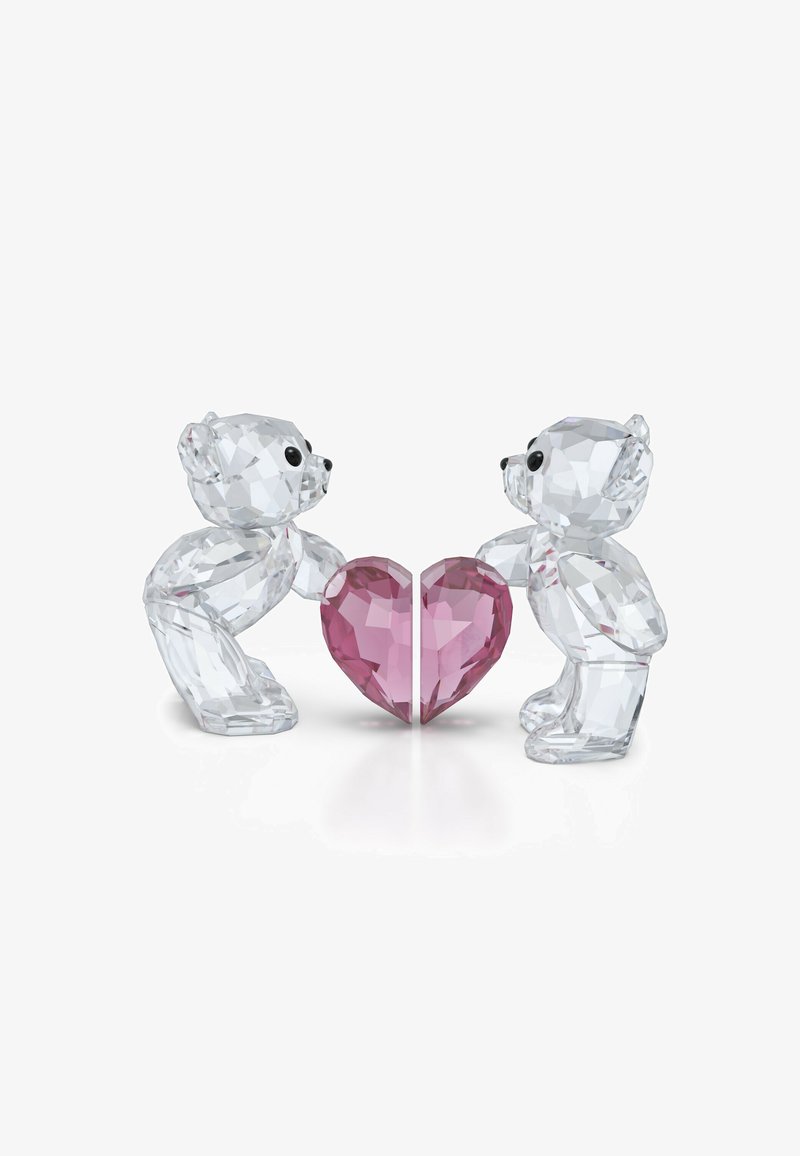 Figurki misiów z kryształu w przezroczystym materiale, trzymające oszlifowane różowe serce, z zaokrąglonymi kształtami i czarnymi oczami, o wypolerowanych powierzchniach.