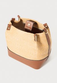 Geweven rieten emmerbag met een bruine leren basis en accenten, met een zachte textuur en bovenste sluitingen. Compacte vorm met versterkte randen.