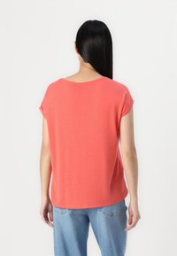Koral kortermet topp laget av myk stoff, med rund halslinning og avslappet passform. Glatt tekstur og enkelt design.