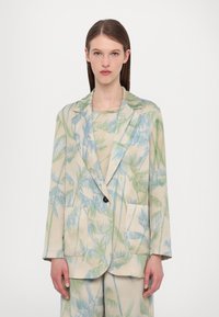 Lightweight blazer in cream with a palm leaf pattern in green and blue. Features a notch lapel, two front pockets, and a single button closure.