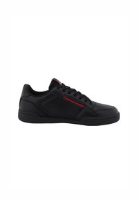 Chaussure de sport noire avec un dessus en cuir lisse, des lacets texturés et un accent rouge contrastant sur le côté. Semelle en caoutchouc plate.