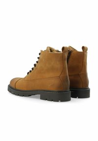 Een paar bruine leren veterschoenen met zwarte robuuste zolen en bontvoering, weergegeven vanuit de achterkant en zijkant op een witte achtergrond.
